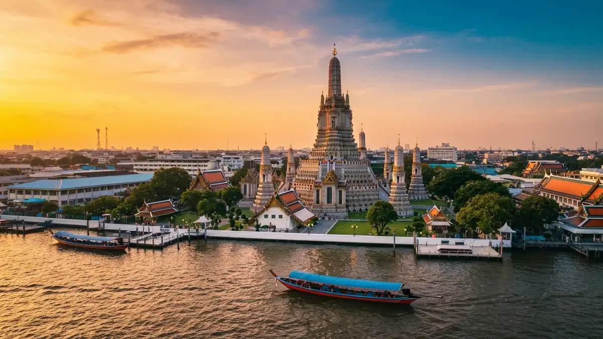 Kolorowy pejzaż Tajlandii z świątynią Wat Arun nad rzeką Chao Phraya w Bangkok, tradycyjne łódki longtail i zachód słońca